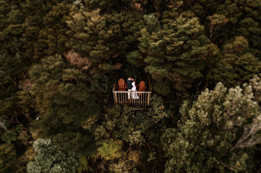 Bride and Groom in Wedding Attire On Forest Lookout Surrounded by Trees , Is Eloping Right For You? 