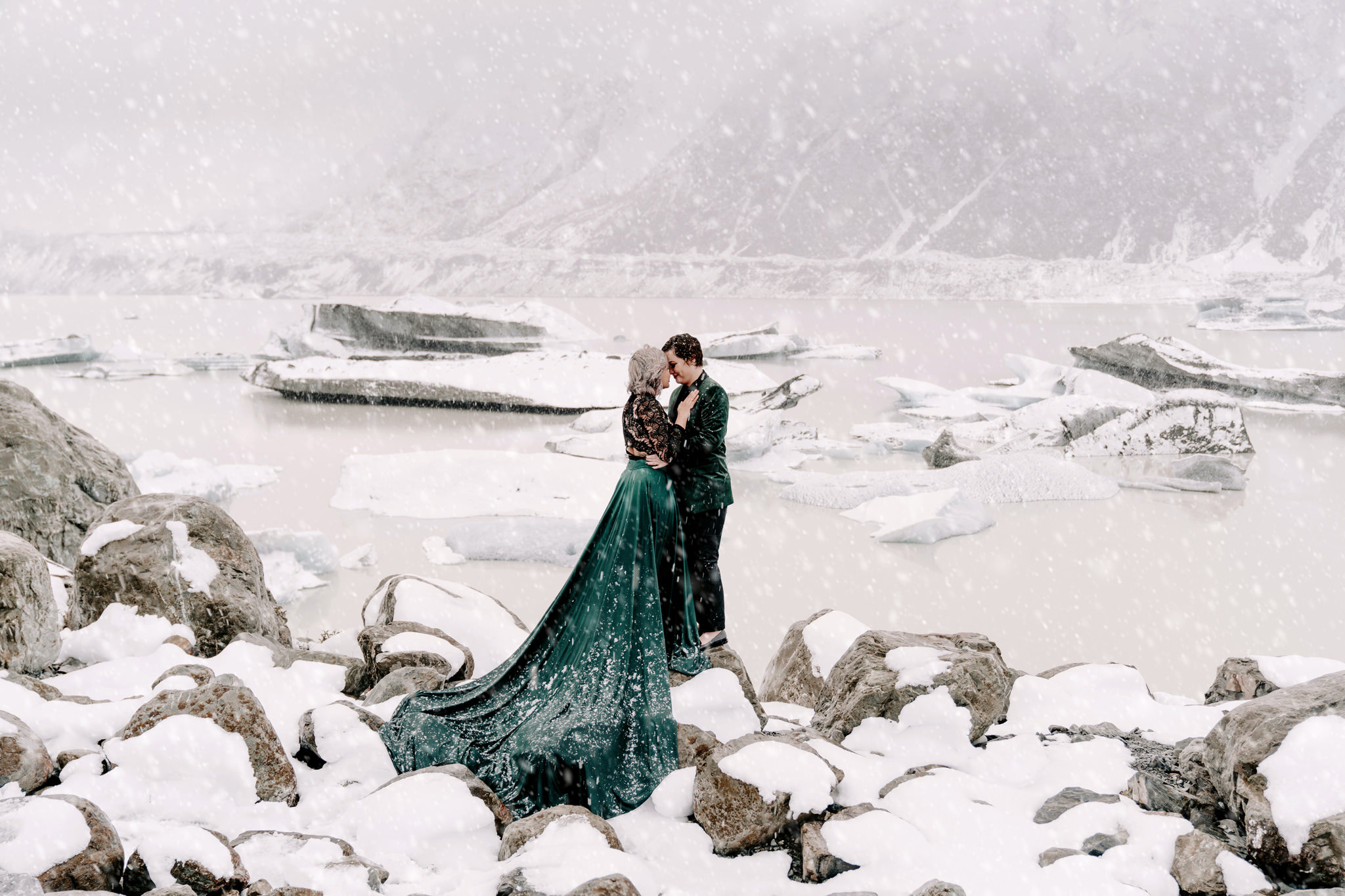 Same sex couple hugging during a snowfall on their elopement day in the Mount Cook National Park