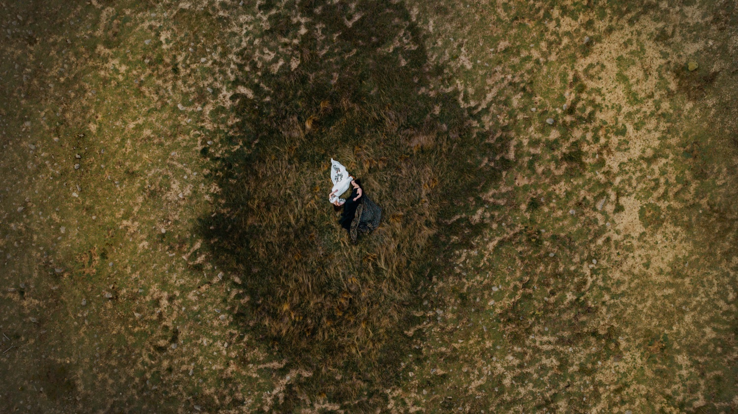 brides lying in the grass at adventure elopement