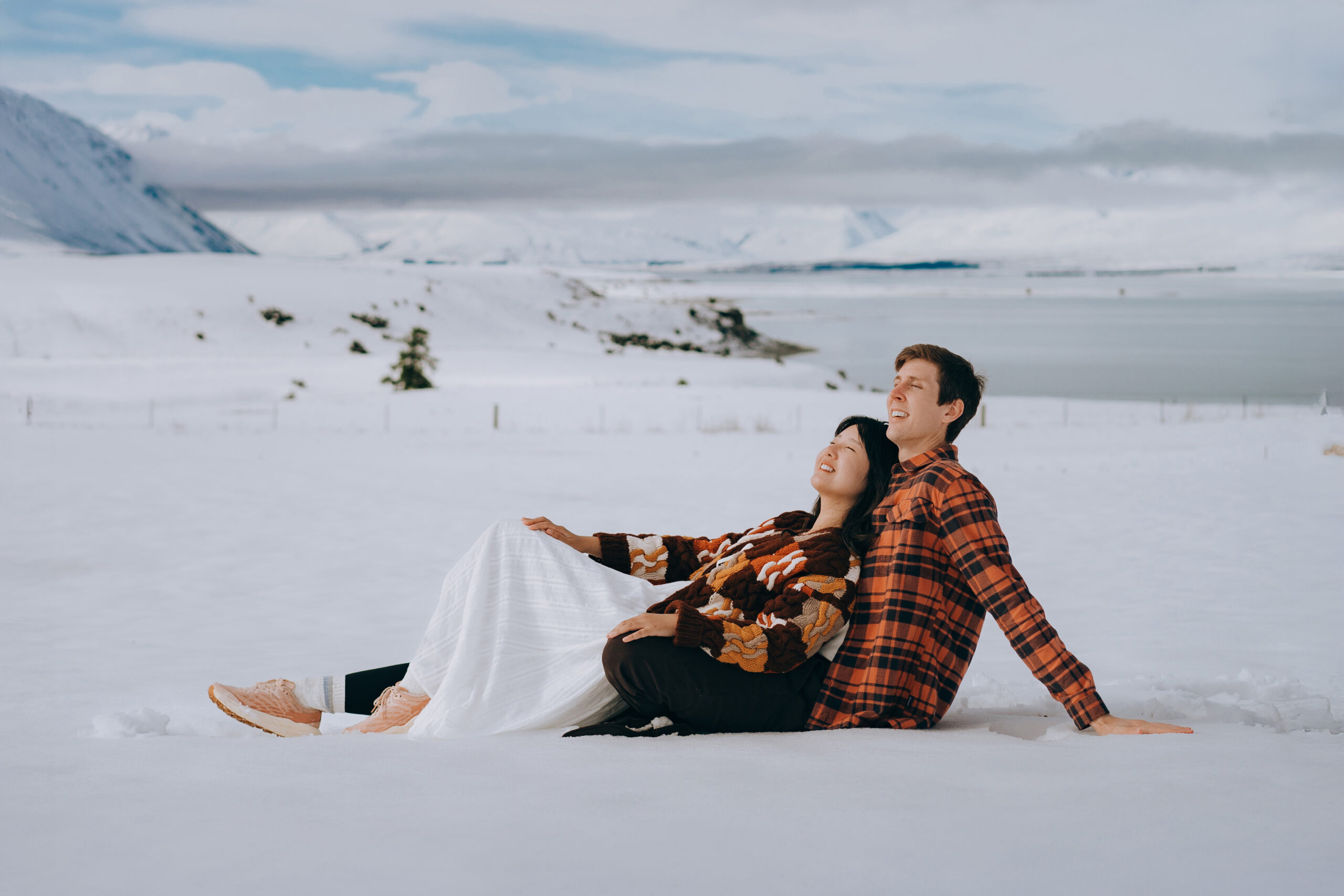 Couple sitting in Snowy Tekapo for their pre wedding photos