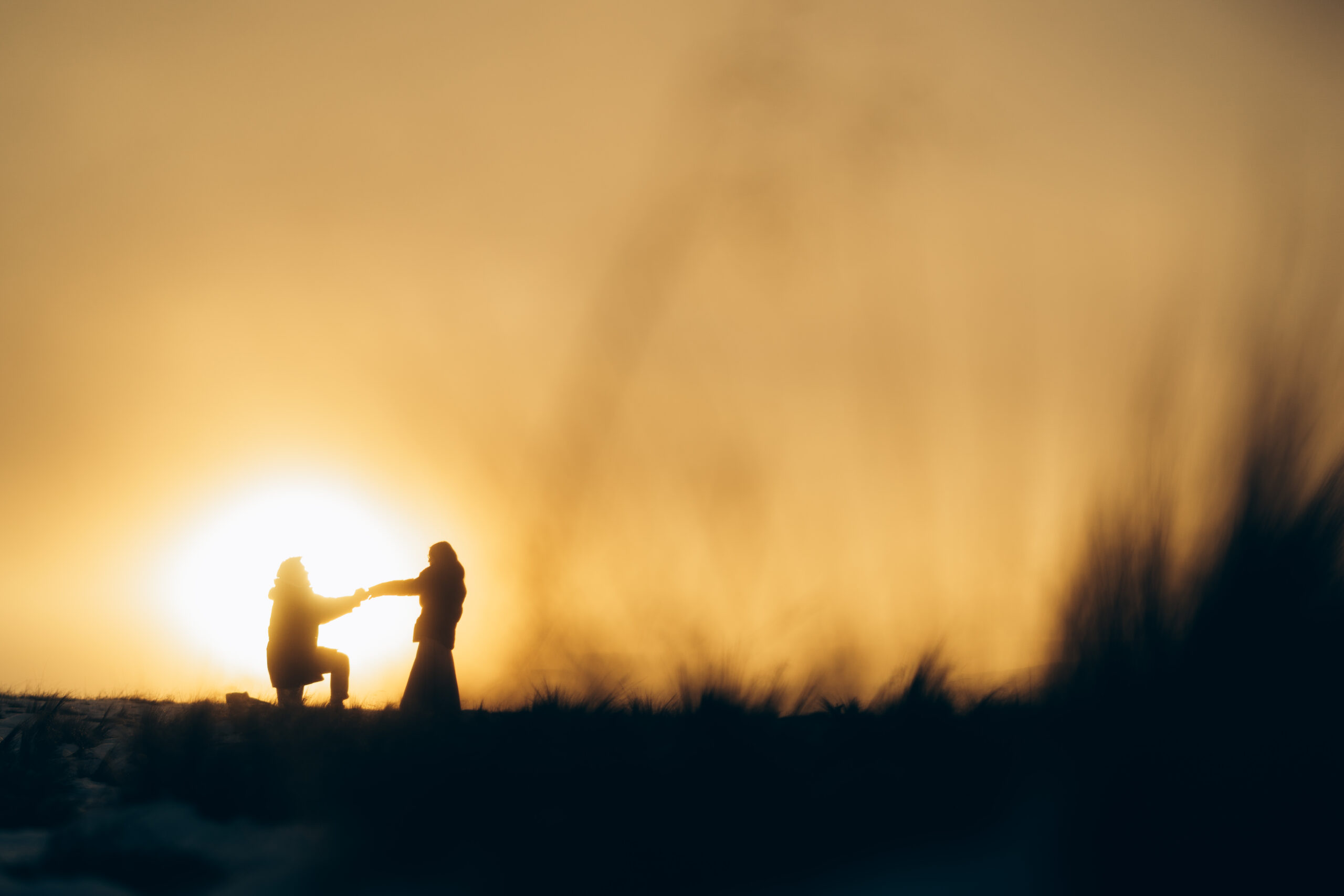 Sunset proposal in Tekapo, silhouette of man proposing to his girlfriend