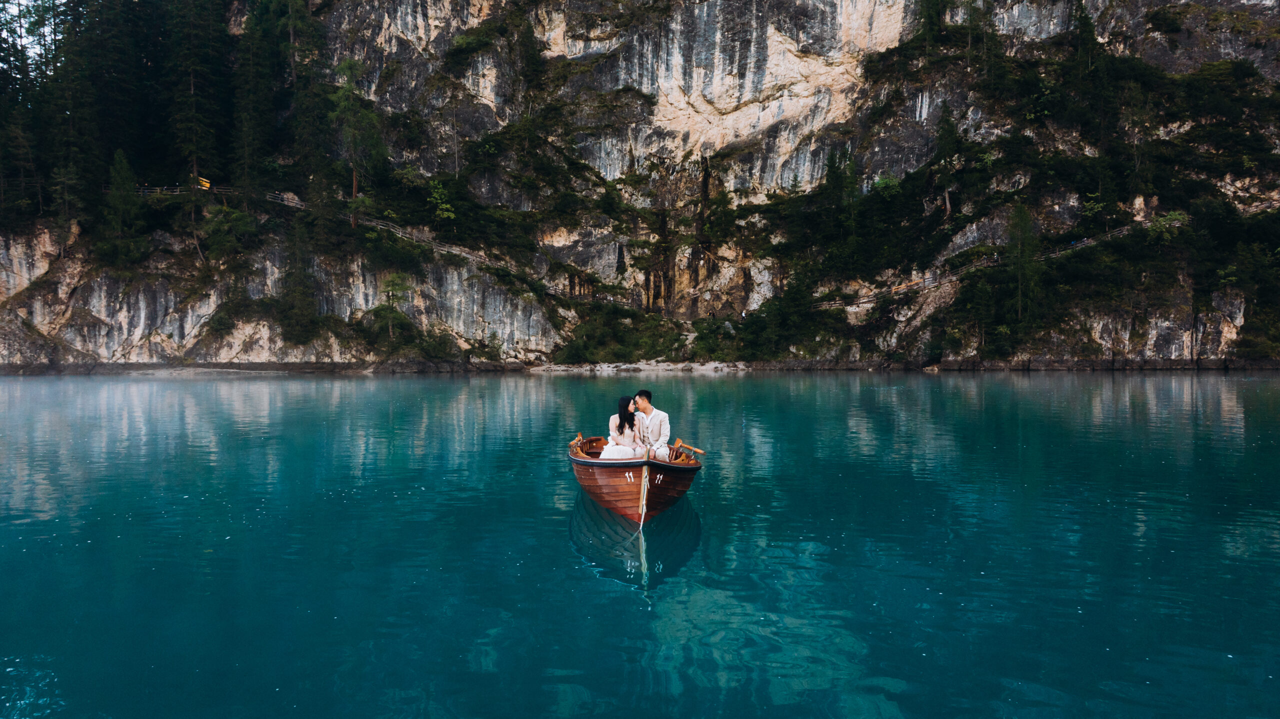 Couple in a boat in Lago di Braies during sunrise