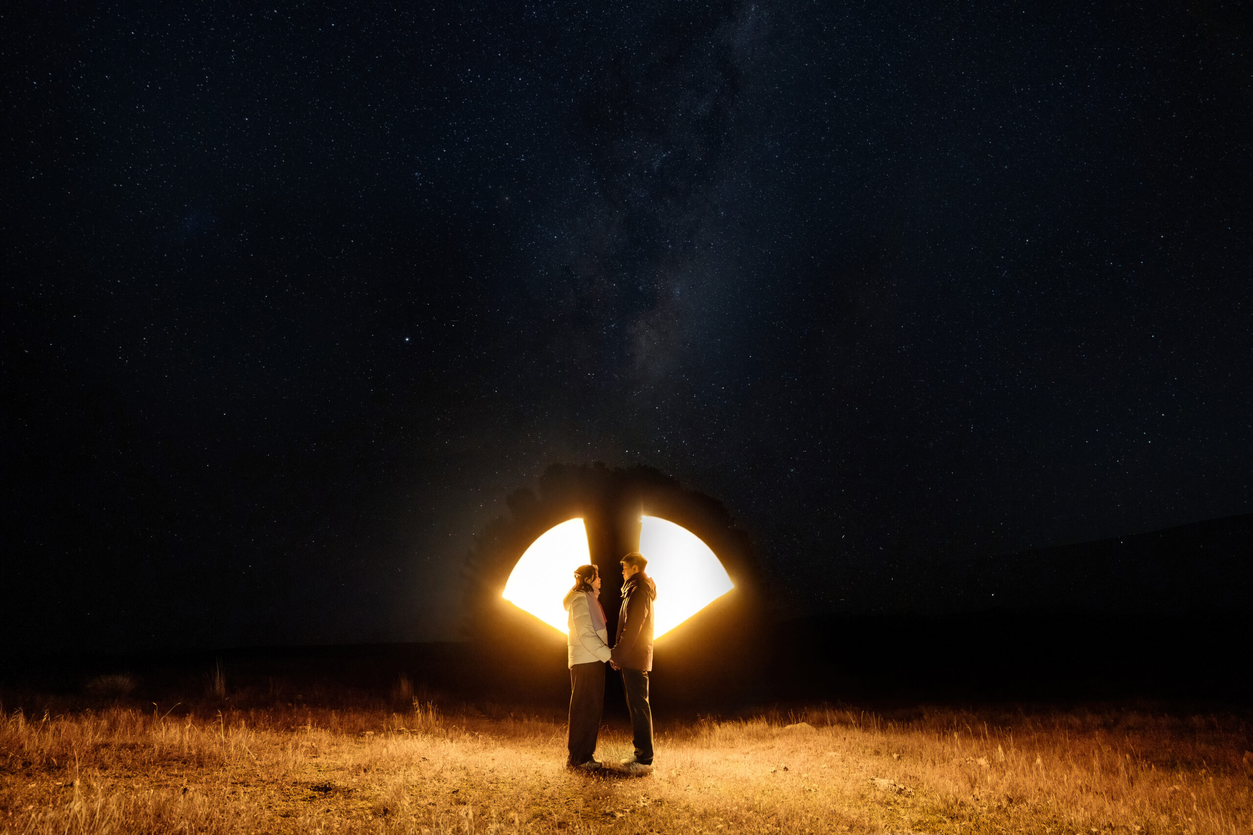 Engaged couple standing under the stars after Winter Surprise Proposal in Tekapo