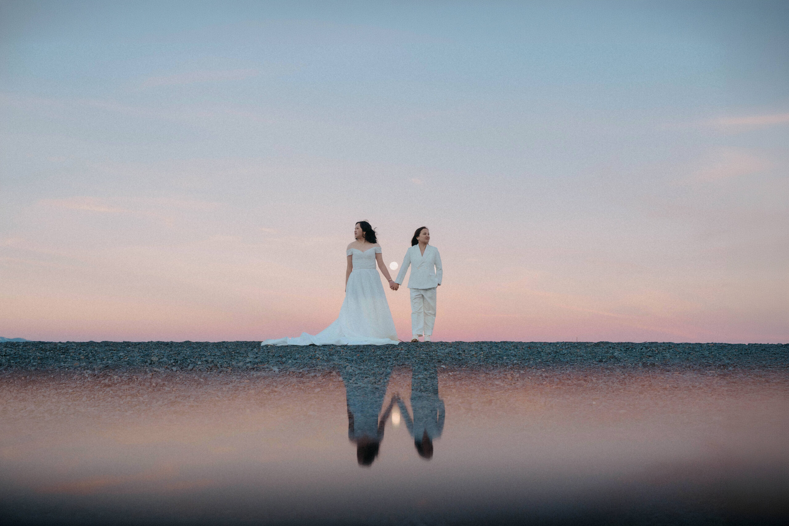 Two brides standing during moonrise in Mount Cook National Park